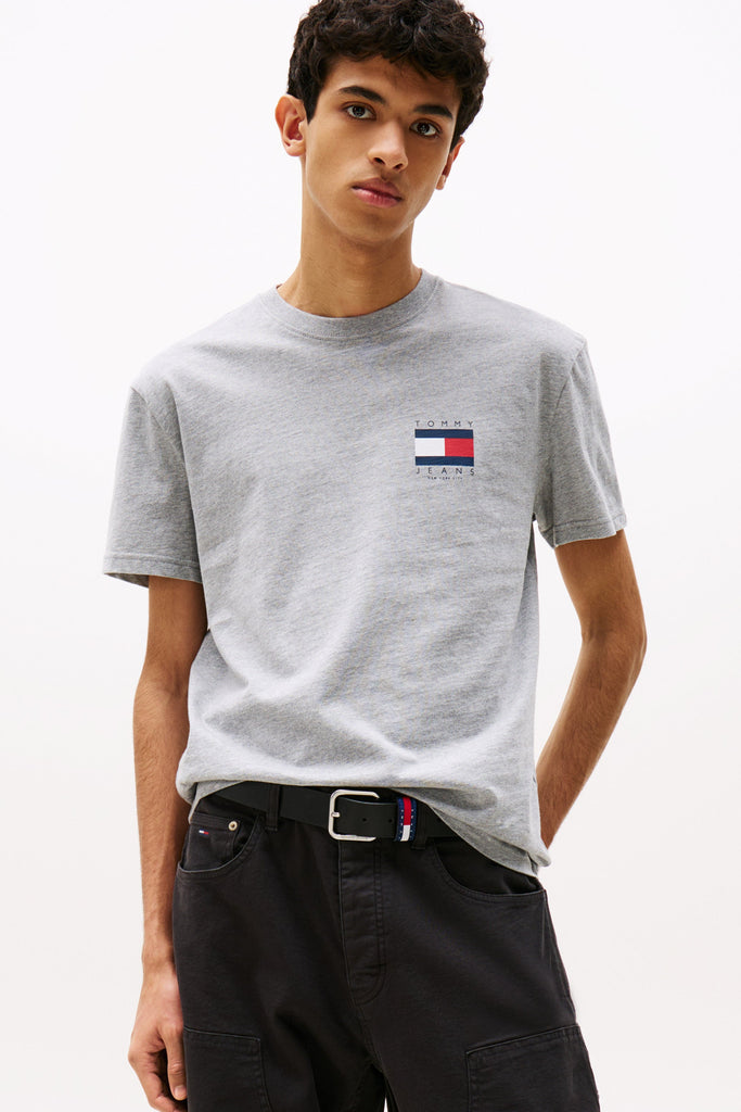 Person wearing a gray t-shirt with a logo on a white background