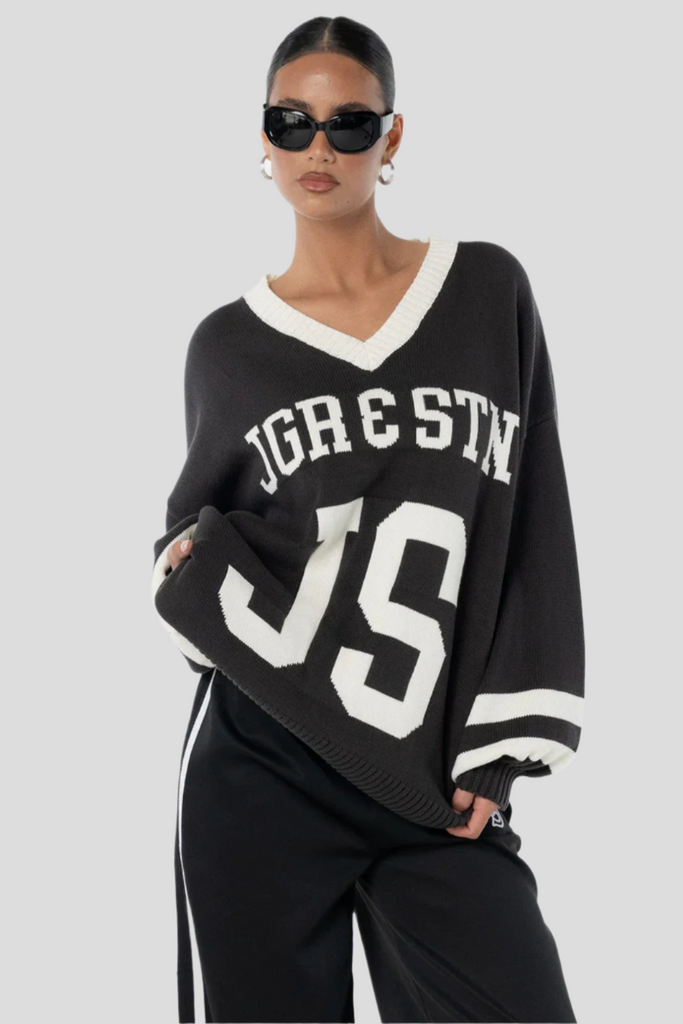 Woman wearing a black sweater with white text and numbers on a white background