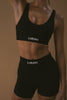 A close view of the Lahana Active Sanaa Crop Top in Black worn by a model with matching bike shorts.